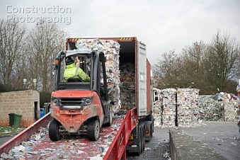 A026-01373_Grip_lift_truck_loading_compacted_paper_recycling_bundles_on_to_lorry_at_recycling_centre
