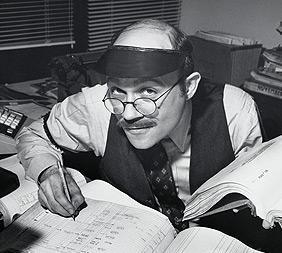 Portrait of a businessman working on accounting ledgers